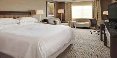 Spacious king suite with TV, business desk, and lounge area at Wyndham Omaha.