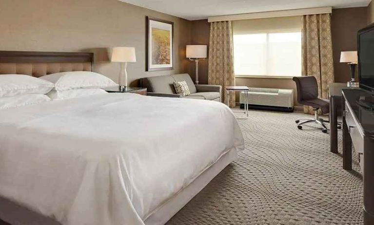 Spacious king suite with TV, business desk, and lounge area at Wyndham Omaha.