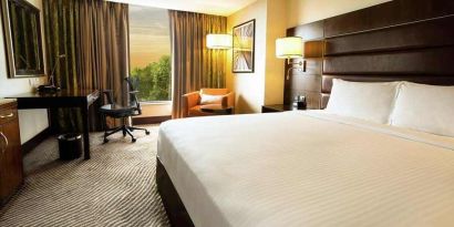 comfortable delux king with TV, business desk, and couch at Hilton Garden Inn Trivandrum.