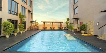 stunning outdoor pool with seating area at Hilton Garden Inn Trivandrum.