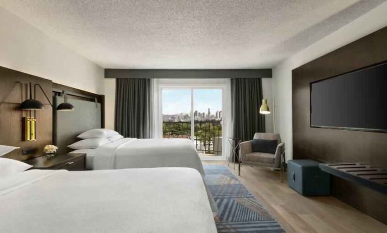 Double queen room with TV screen at the Embassy Suites by Hilton Los Angeles Downey.