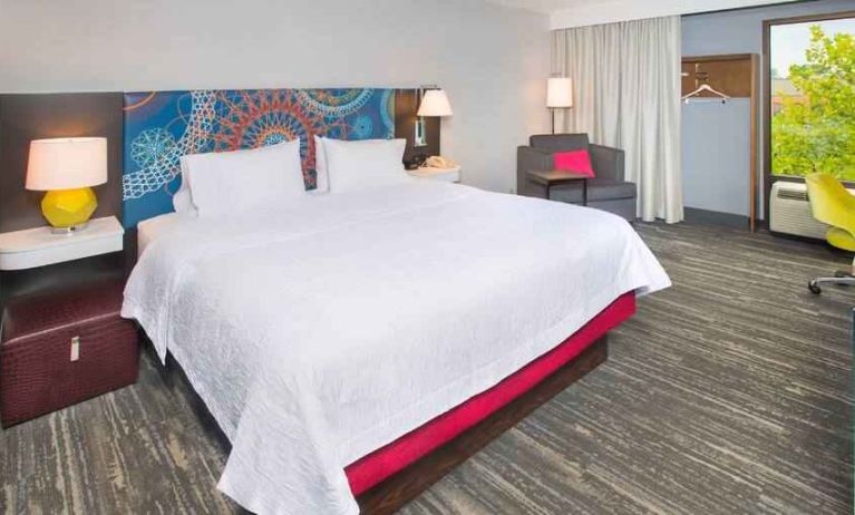 colorful king bedroom with natural light and work desk ideal for working remotely at Hampton Inn & Suites Annapolis.