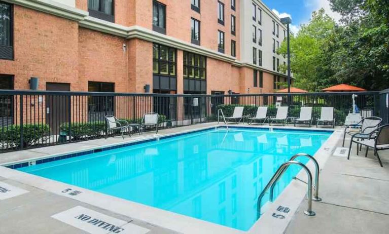 large outdoor pool with sunbeds and outdoor seating at Hampton Inn & Suites Annapolis.