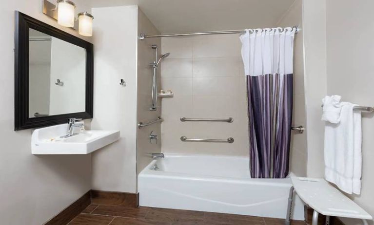 Guest bathroom with shower and tub at La Quinta Inn & Suites By Wyndham New York City Central Park.