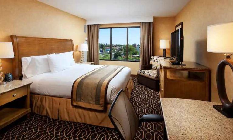 Bright king bedroom with window and working station at the DoubleTree Suites by Hilton Anaheim Resort-Convention Center.