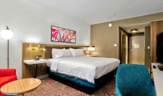 Queen size bed with TV, ottoman, chair and table to sit at Hilton Garden Inn Bel Air.