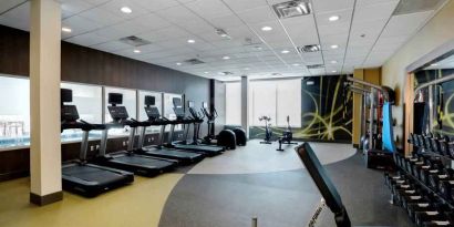 Large fitness room with 3 treadmills, 2 eliptical machines, freeweights, area for stretching and cable machine for resistance training.