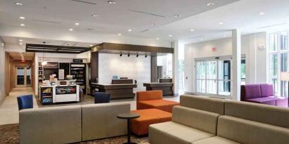 Gray, salmon and purple colored couches decorate the lobby area of the Hilton Garden Inn Bel Air.