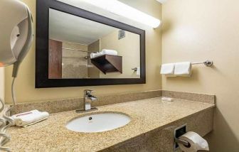 Clean and spacious guest bathroom at Red Roof PLUS+ & Suites Houston - IAH Airport SW.