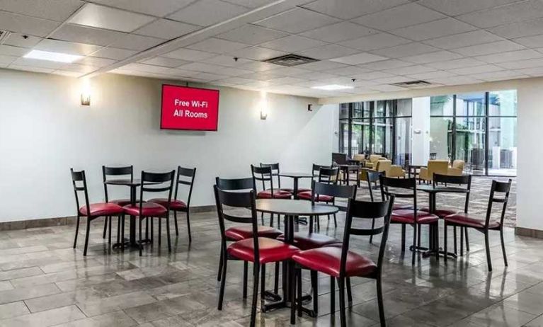 Open-plan dining and coworking space at Red Roof PLUS+ & Suites Houston - IAH Airport SW.