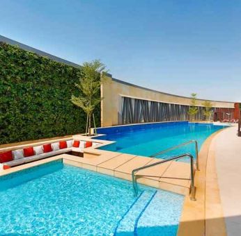 Relaxing outdoor pool at the AlRayyan Hotel Doha, Curio Collection by Hilton.