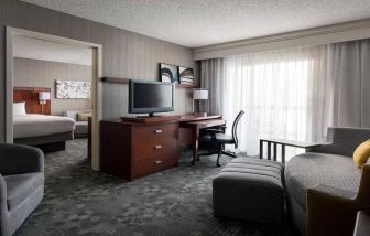 Luxurious king suite with lounge, TV, and work desk at Sonesta Select Phoenix Chandler.