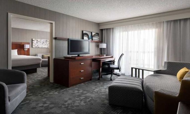 Luxurious king suite with lounge, TV, and work desk at Sonesta Select Phoenix Chandler.