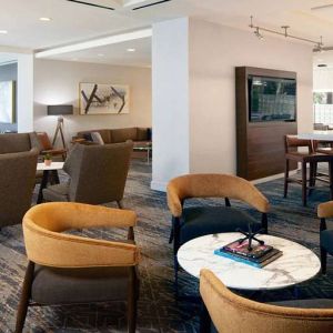 Seating area with TV screen at Courtyard By Marriott Los Angeles LAX/Century Boulevard.