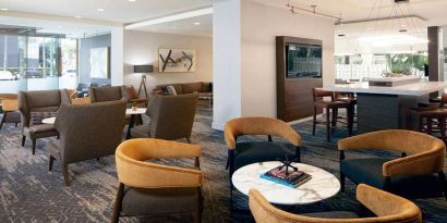 Seating area with TV screen at Courtyard By Marriott Los Angeles LAX/Century Boulevard.