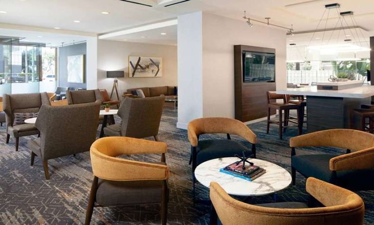 Seating area with TV screen at Courtyard By Marriott Los Angeles LAX/Century Boulevard.