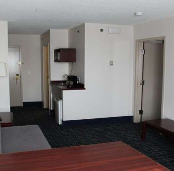 Family room with TV screen and sofa at Riviera Plaza And Conference Centre Calgary Airport.