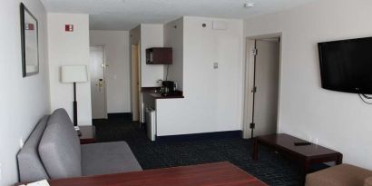 Family room with TV screen and sofa at Riviera Plaza And Conference Centre Calgary Airport.