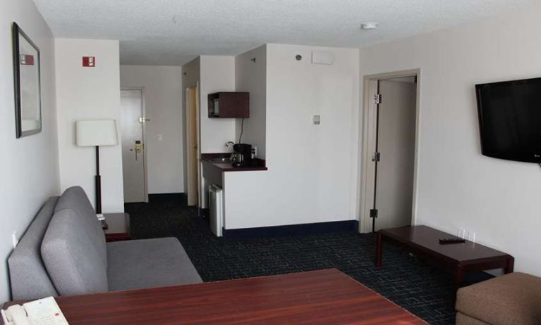 Family room with TV screen and sofa at Riviera Plaza And Conference Centre Calgary Airport.