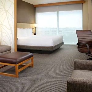 Hotel room with sofa and desk at Hyatt Place Miami Airport East.