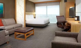 Hotel room with sofa and desk at Hyatt Place Miami Airport East.