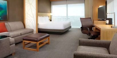 Hotel room with sofa and desk at Hyatt Place Miami Airport East.