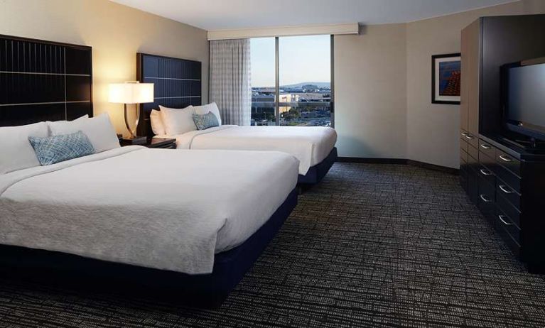 Twin room with TV screen and sofa at Embassy Suites By Hilton LAX Airport North.