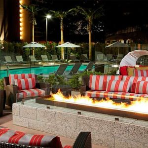 Beautiful outdoor patio by the pool with firepit at Residence Inn By Marriott LAX Airport.