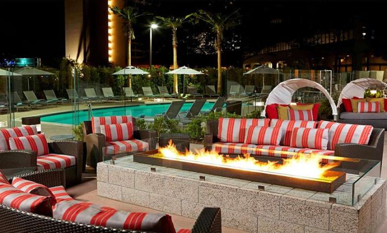 Beautiful outdoor patio by the pool with firepit at Residence Inn By Marriott LAX Airport.