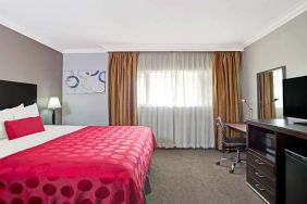 King bedroom with desk at Ramada Los Angeles Downtown West.