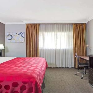 King bedroom with desk at Ramada Los Angeles Downtown West.