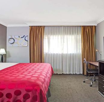 King bedroom with desk at Ramada Los Angeles Downtown West.