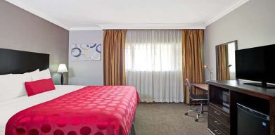 King bedroom with desk at Ramada Los Angeles Downtown West.