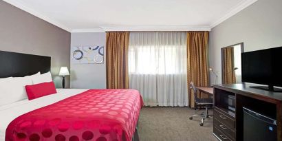 King bedroom with desk at Ramada Los Angeles Downtown West.