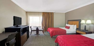 Twin room with desk, TV screen and table at Ramada Los Angeles Downtown West.