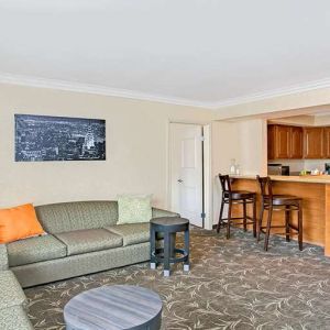 Living room with kitchenette and sofa at Ramada Los Angeles Downtown West.