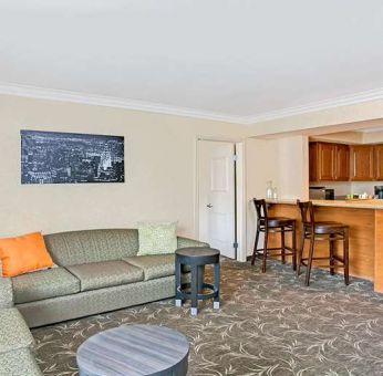 Living room with kitchenette and sofa at Ramada Los Angeles Downtown West.