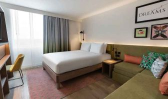 Queen bedroom with corner sofa at the Hampton by Hilton Istanbul Arnavutkoy.