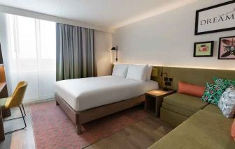 Queen bedroom with corner sofa at the Hampton by Hilton Istanbul Arnavutkoy.