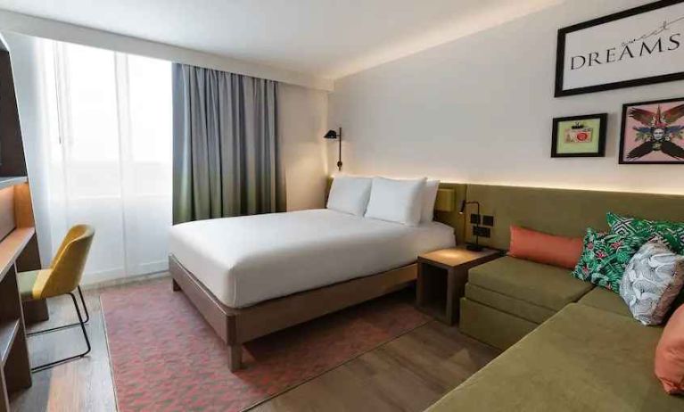 Queen bedroom with corner sofa at the Hampton by Hilton Istanbul Arnavutkoy.