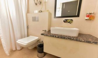 clean and spacious guest bathroom with shower at Hotel Luxury Stay.