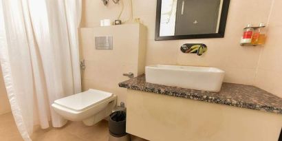 clean and spacious guest bathroom with shower at Hotel Luxury Stay.