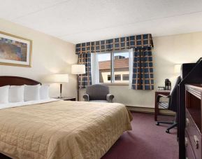 Hotel bedroom with TV screen and desk at Travelodge Ottawa East.