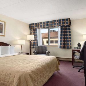 Hotel bedroom with TV screen and desk at Travelodge Ottawa East.