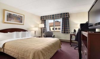 Hotel bedroom with TV screen and desk at Travelodge Ottawa East.