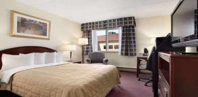 Hotel bedroom with TV screen and desk at Travelodge Ottawa East.