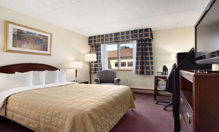 Hotel bedroom with TV screen and desk at Travelodge Ottawa East.