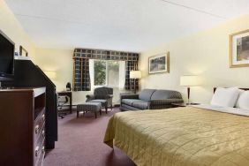 King bedroom with TV screen and workstation at Travelodge Ottawa East.