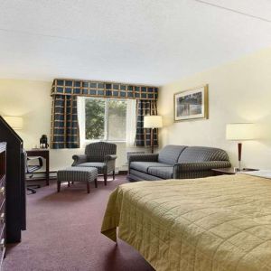 King bedroom with TV screen and workstation at Travelodge Ottawa East.