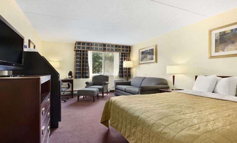 King bedroom with TV screen and workstation at Travelodge Ottawa East.